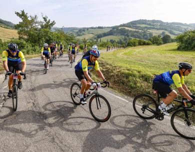 Ciclisti percorrono una strada panoramica in campagna.