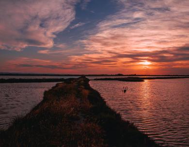 Tramonto su un lago con nuvole colorate.