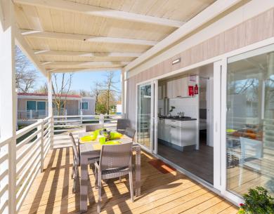 Terrasse avec table et cuisine moderne dans une maison mobile.