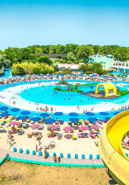 Parc aquatique avec piscines, toboggans et parasols colorés.