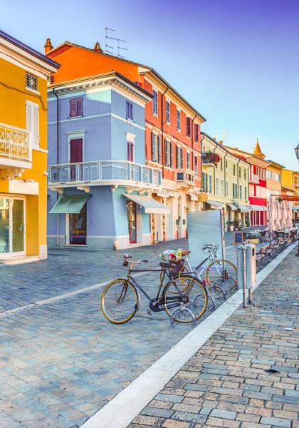 Colorful houses by the canal with bikes and boats.