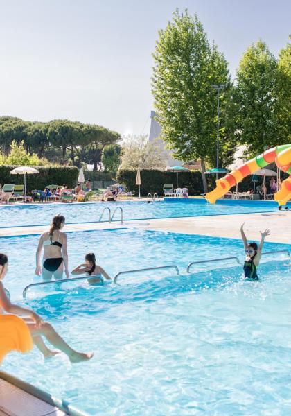 Freibad mit Rutschen und Menschen, die die Sonne genießen.