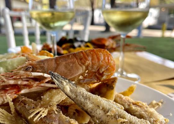 Fritto misto di pesce con vino bianco all'aperto.